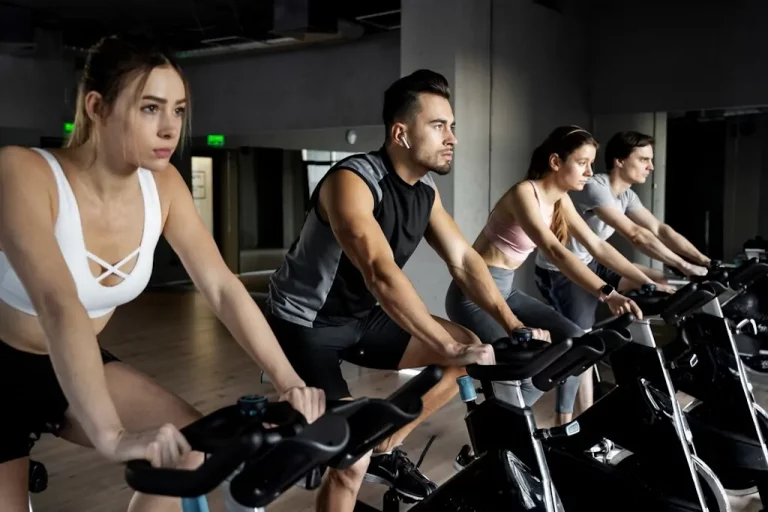 Perder peso de forma saludable pedaleando en bicicleta en un entorno de gimnasio