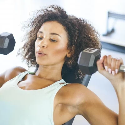 Mujer haciendo pesas en gimnasio