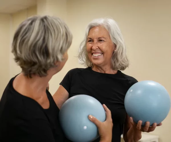 Mujeres adultas mayores participando en una clase grupal en el gimnasio
