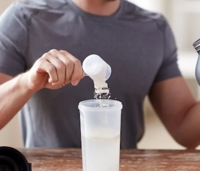 Chico añadiendo creatina en shaker con agua